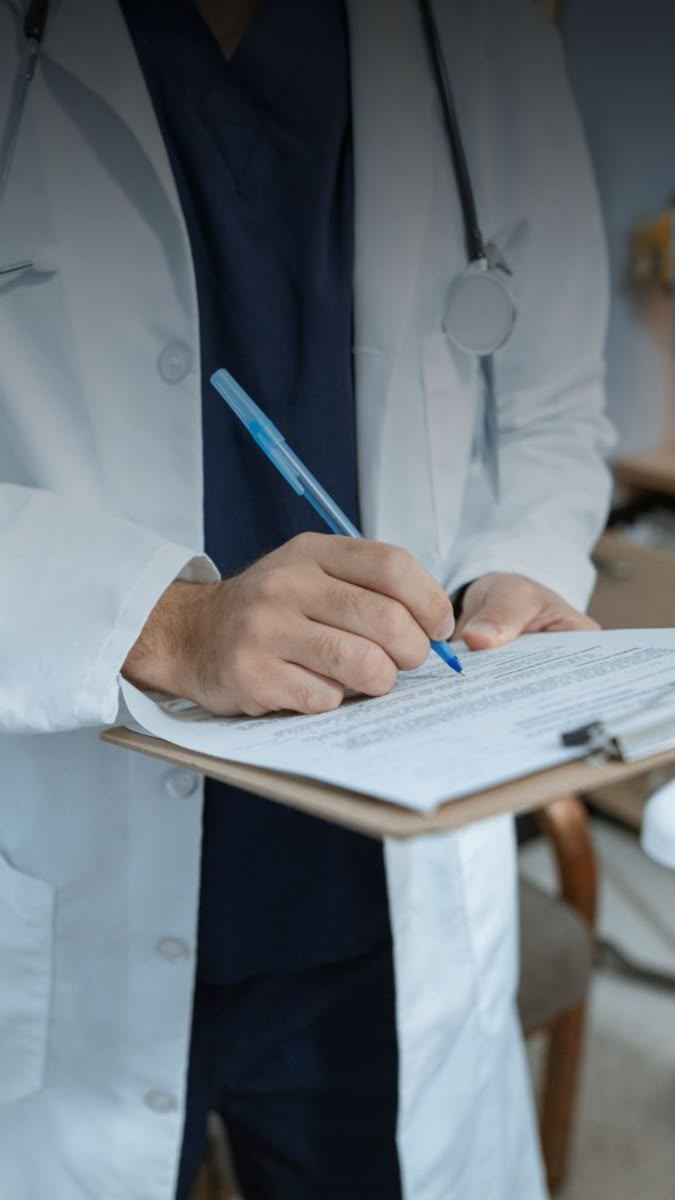 Doctor writing on a medical prescription form